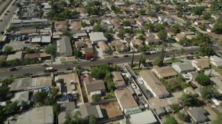 AX68_001 - 4.8K stock footage aerial video reverse view of urban neighborhoods, revealing warehouse buildings in Pacoima, California