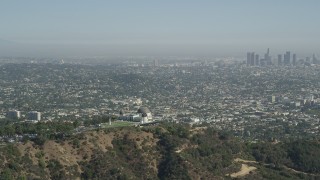 AX68_004 - 4.8K aerial stock footage Griffith Observatory with a view of Downtown Los Angeles skyline, California