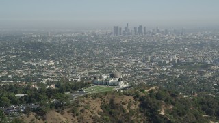 AX68_005 - 4.8K aerial stock footage pass by Griffith Observatory with Downtown Los Angeles in the distance, California
