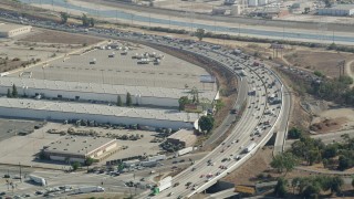 AX68_035 - 4.8K aerial stock footage approach heavy freeway traffic by warehouse buildings in Vernon, Los Angeles, California