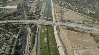 AX68_048 - 4.8K stock footage aerial video reverse bird's eye view of the Los Angeles River, reveal freeway interchange in Long Beach, California