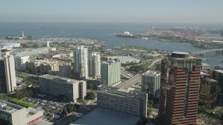 AX68_051 - 4.8K aerial stock footage fly over office buildings to approach the harbors and Queen Mary in Long Beach, California