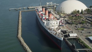 AX68_065 - 4.8K aerial stock footage of passing the starboard side of the Queen Mary luxury liner in Long Beach, California