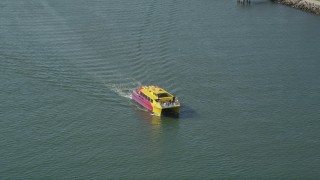AX68_073 - 4.8K aerial stock footage of a small yellow and red ferry sailing San Pedro Bay in Long Beach, California