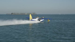AX68_077 - 4.8K aerial stock footage track a seaplane taking off from San Pedro Bay in Long Beach, California