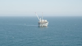 AX68_088 - 4.8K aerial stock footage tilt to reveal and approach an offshore oil platform near Long Beach, California