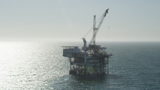 AX68_092 - 4.8K aerial stock footage orbit an oceanic oil drilling platform near Long Beach, California