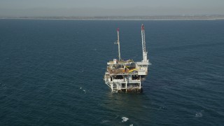 AX68_099 - 4.8K stock footage aerial video orbit of an oil platform off the California Coast, near Long Beach