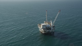 AX68_100 - 4.8K aerial stock footage of circling an oil platform off the California Coast, near Long Beach