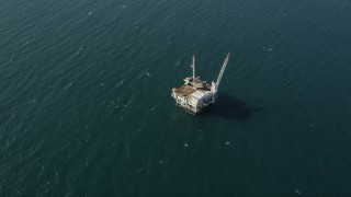 AX68_105 - 4.8K aerial stock footage of looking down at an oceanic oil platform near the coast of California, Long Beach