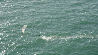AX68_119 - 4.8K aerial stock footage of tracking a kite surfer cruising across San Pedro Bay, Long Beach, California