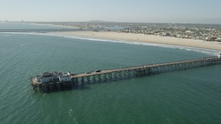 AX68_124 - 4.8K aerial stock footage flyby the end of Seal Beach Municipal Pier by beach and coastal neighborhoods in Seal Beach, California