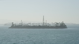 AX68_126 - 4.8K aerial stock footage approach the oil drilling Island Chaffee in San Pedro Bay, Long Beach, California