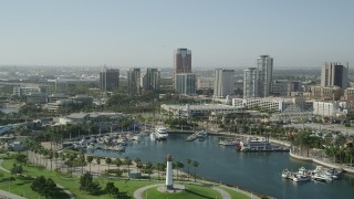 AX68_136 - 4.8K aerial stock footage fly over lighthouse, Shoreline Aquatic Park, and aquarium to approach office buildings in Downtown Long Beach, California