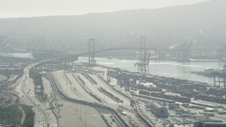 AX68_144 - 4.8K aerial stock footage approach train yard and Vincent Thomas Bridge at the Port of Los Angeles, California
