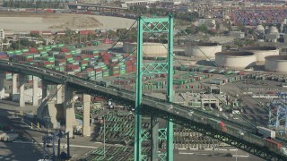 AX68_153 - 4.8K aerial stock footage of Vincent Thomas Bridge and light traffic at the Port of Los Angeles, California