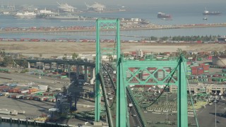 AX68_155 - 4.8K aerial stock footage flyby Vincent Thomas Bridge with light traffic at the Port of Los Angeles, California