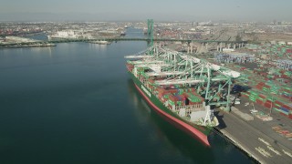 AX68_163 - 4.8K aerial stock footage flyby docked cargo ship to approach Vincent Thomas Bridge at Port of Los Angeles, California