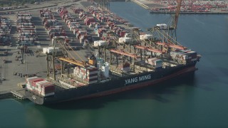AX68_167 - 4.8K aerial stock footage approach and flyby a cargo ship being unloaded at the Port of Los Angeles, California