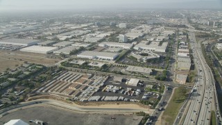AX68_180 - 4.8K aerial stock footage approach office and warehouse buildings by I-110 in Torrance, California