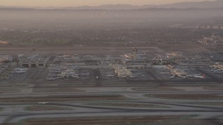 AX69_007 - 4.8K aerial stock footage of terminals and control tower at LAX at sunset, Los Angeles, California