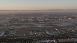 AX69_009 - 4.8K aerial stock footage of a view of runways, terminals and hangars at LAX at twilight, Los Angeles, California