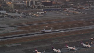 AX69_011 - 4.8K aerial stock footage track American Airlines passenger jet landing at LAX at sunset, Los Angeles, California