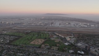 AX69_018 - 4.8K aerial stock footage pan across Los Angeles International Airport at sunset in California
