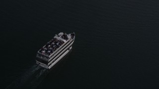 AX69_022 - 4.8K aerial stock footage of tracking a ferry on the water in Marina Del Rey at sunset, California
