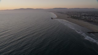 AX69_025 - 4.8K aerial stock footage tilt to reveal Venice Fishing Pier and empty beach to Santa Monica at sunset, California