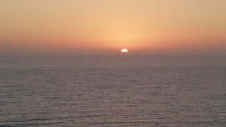 AX69_026 - 4.8K stock footage video of Pacific Ocean with the setting sun in the distance