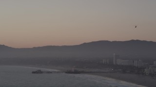 AX69_027 - 4.8K aerial stock footage tilt from helicopter to reveal Santa Monica Pier at sunset, California