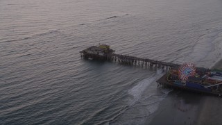 AX69_033 - 4.8K aerial stock footage approach and the end of Santa Monica Pier at twilight, California