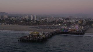 AX69_035 - 4.8K aerial stock footage orbit the end of Santa Monica Pier and the Pacific Wheel at twilight, California
