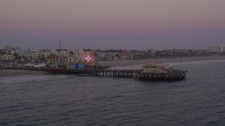 AX69_036 - 4.8K aerial stock footage orbit and fly away from the end of Santa Monica Pier at twilight, California