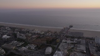 AX69_038 - 4.8K aerial stock footage flyby beachside buildings and Santa Monica Pier at twilight, California