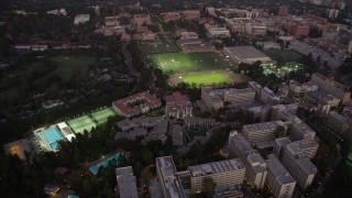 AX69_055 - 4.8K aerial stock footage orbit College sports fields and campus buildings at twilight, Westwood, California