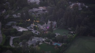 AX69_062 - 4.8K aerial stock footage of orbiting the Playboy Mansion in Los Angeles, California, twilight