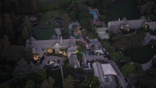 AX69_065 - 4.8K aerial stock footage of circling The Playboy Mansion and grounds at twilight, Los Angeles, California