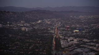 AX69_068 - 4.8K aerial stock footage of Santa Monica Boulevard through West Hollywood at twilight, California