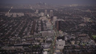 AX69_069 - 4.8K aerial stock footage tilt from Wilshire Boulevard in Beverly Hills to reveal Downtown Los Angeles, California, twilight