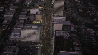 AX69_071 - 4.8K aerial stock footage follow Wilshire Boulevard past office buildings in Beverly Hills, California, twilight
