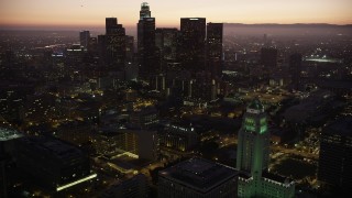 AX69_085 - 4.8K aerial stock footage orbit Los Angeles City Hall and reveal skyscrapers in Downtown Los Angeles at twilight, California