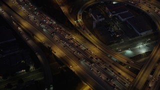 AX69_097 - 4.8K aerial stock footage of bird's eye view of the I-110 / 10 interchange in Downtown Los Angeles, California at night