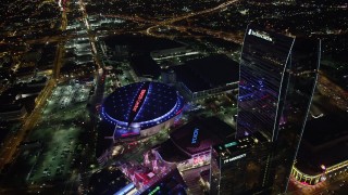 AX69_126 - 4.8K stock footage aerial video approach and tilt to Staples Center and Nokia Theater in Downtown Los Angeles, California at night