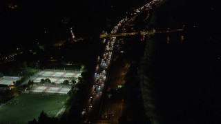 AX69_138 - 4.8K aerial stock footage of heavy traffic on Interstate 5 at night in Los Feliz, Los Angeles, California