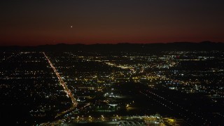 AX69_145 - 4.8K aerial stock footage of runways at Burbank Airport and suburban neighborhoods at night, California