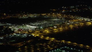 AX69_147 - 4.8K aerial stock footage of a strip mall by Burbank Airport terminals at night in Burbank, California