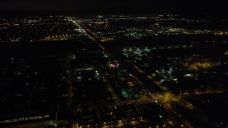 AX69_152 - 4.8K aerial stock footage of Pacoima warehouse buildings on San Fernando Road at nighttime, California