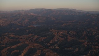 AX70_005 - 4K aerial stock footage Fly over Los Padres National Forest to approach a lake at sunrise, California